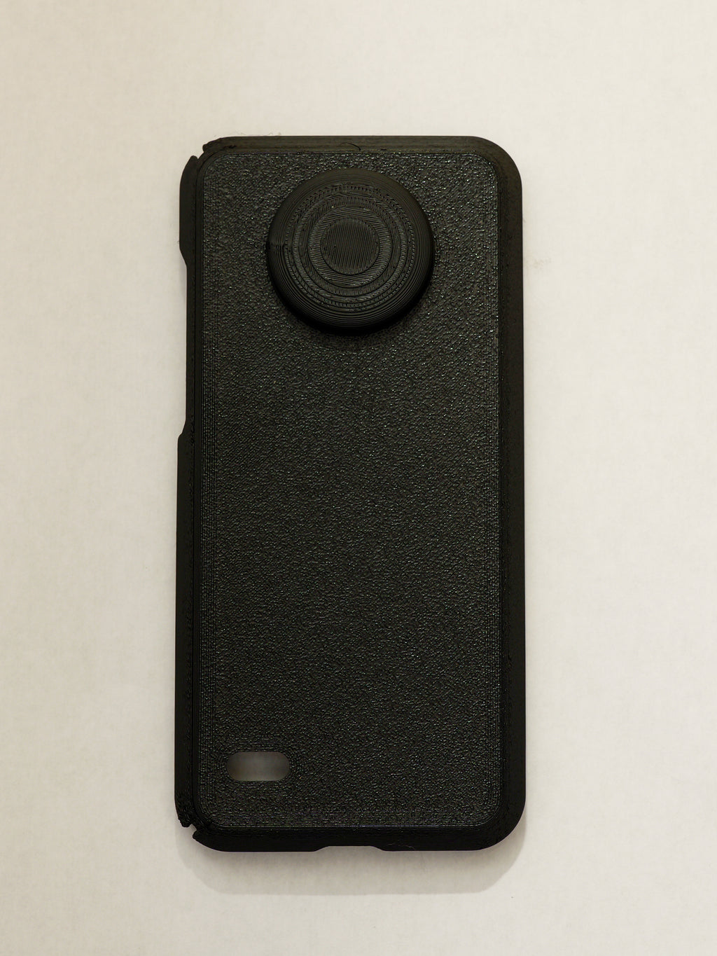 Black phone case with a textured finish on a light beige background