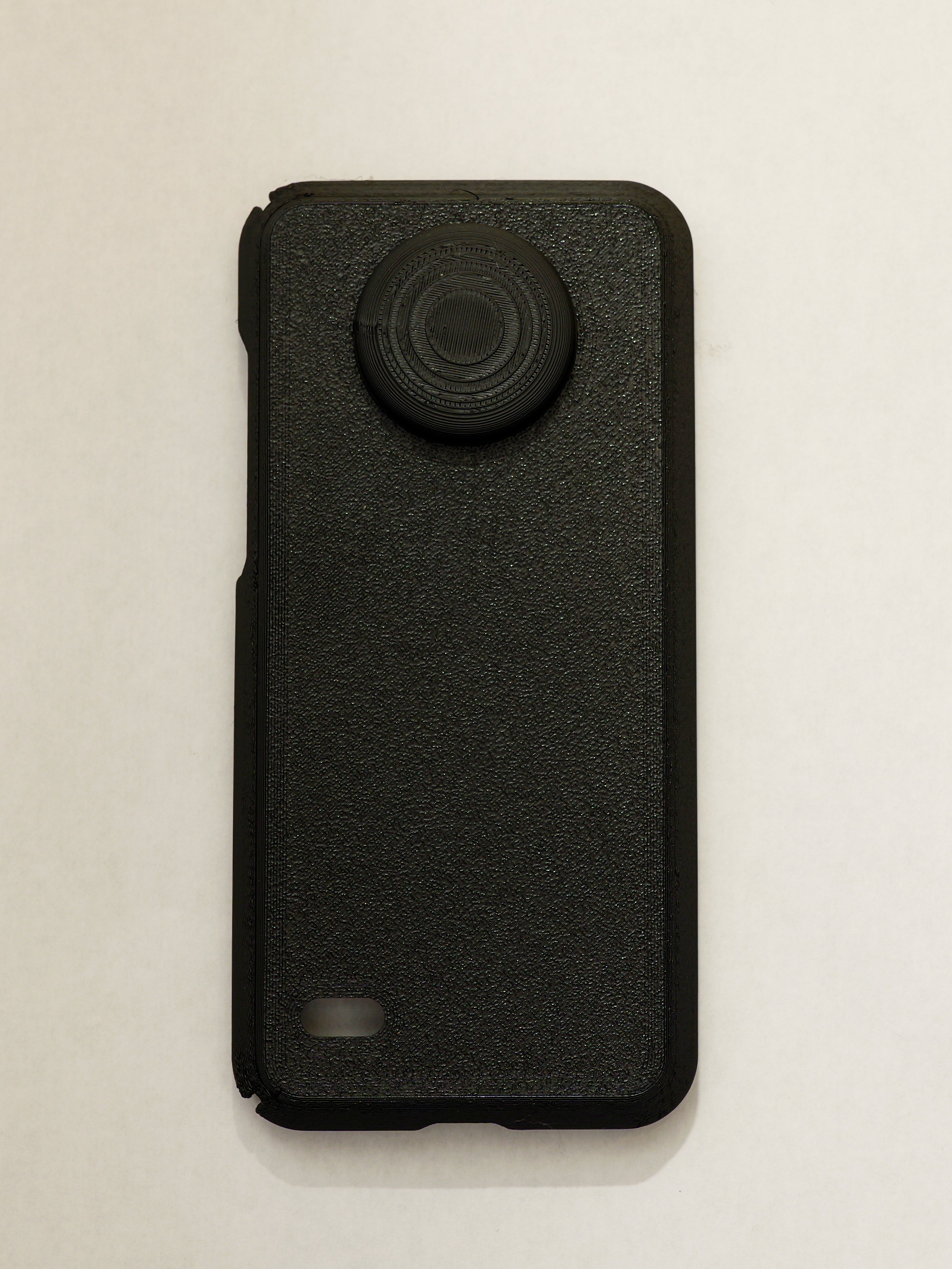 Black phone case with a textured finish on a light beige background