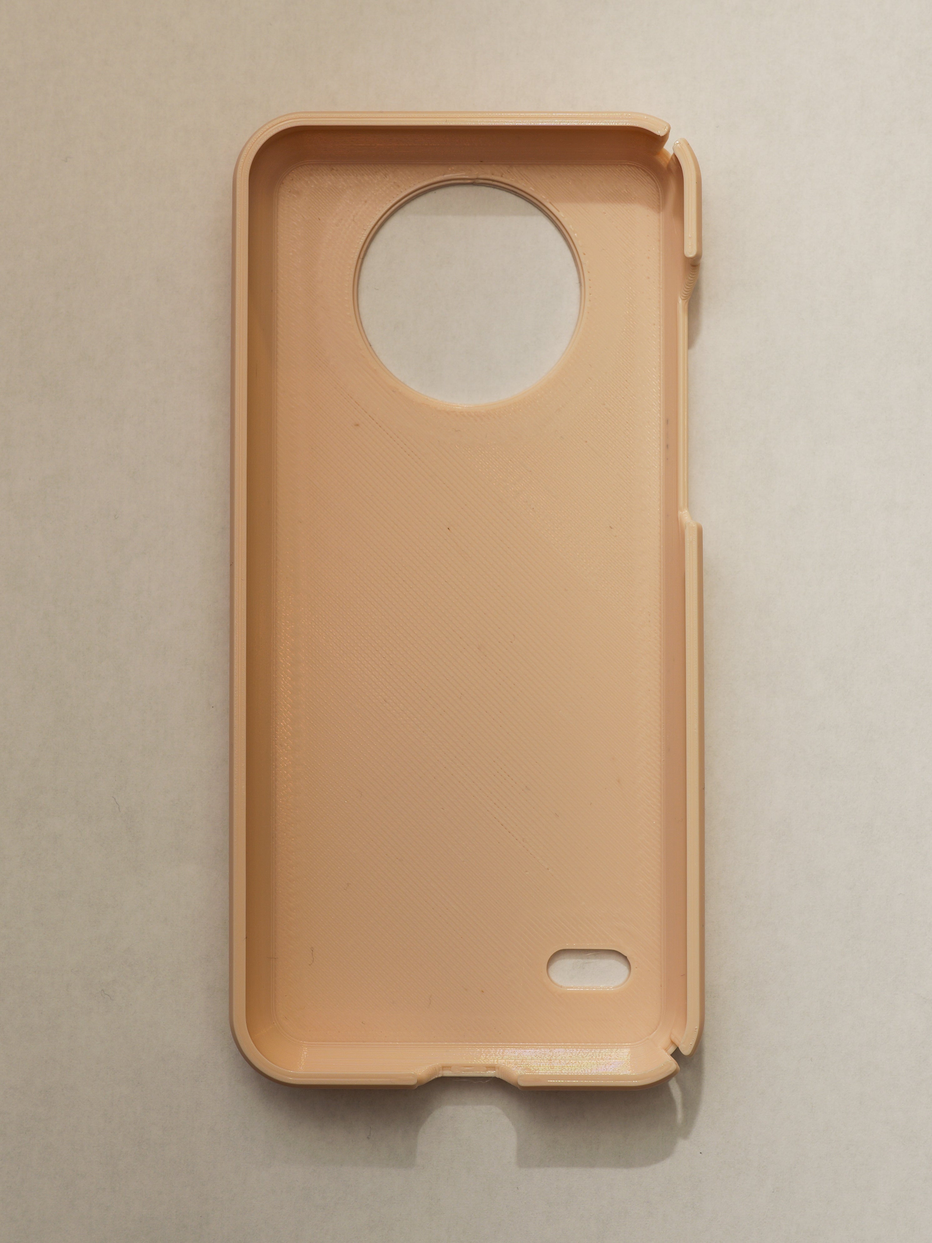 Beige phone case with a circular cutout on a beige background