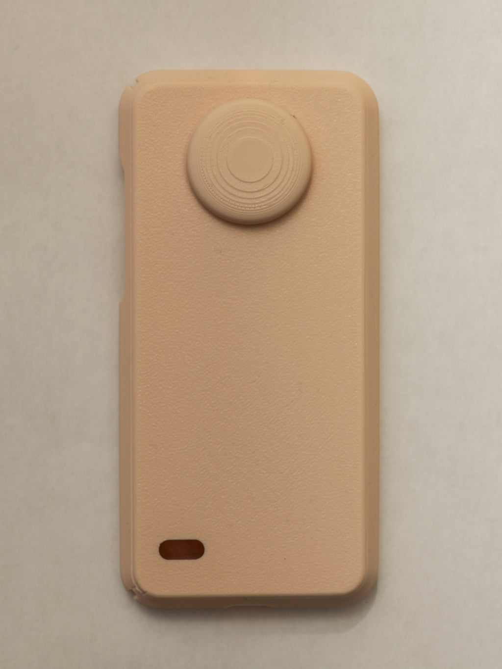 Beige phone case with a circular design on a beige background