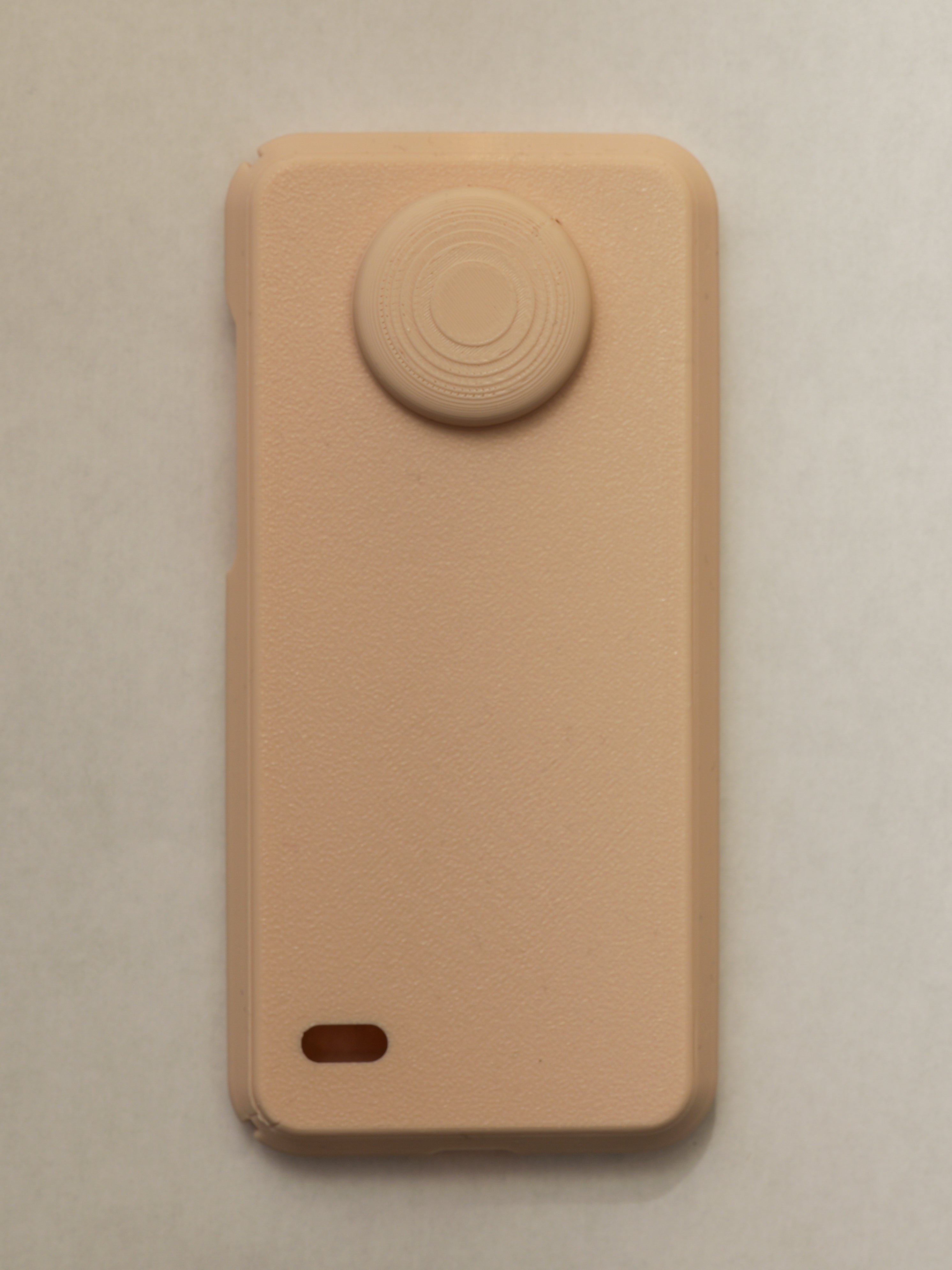Beige phone case with a circular design on a beige background