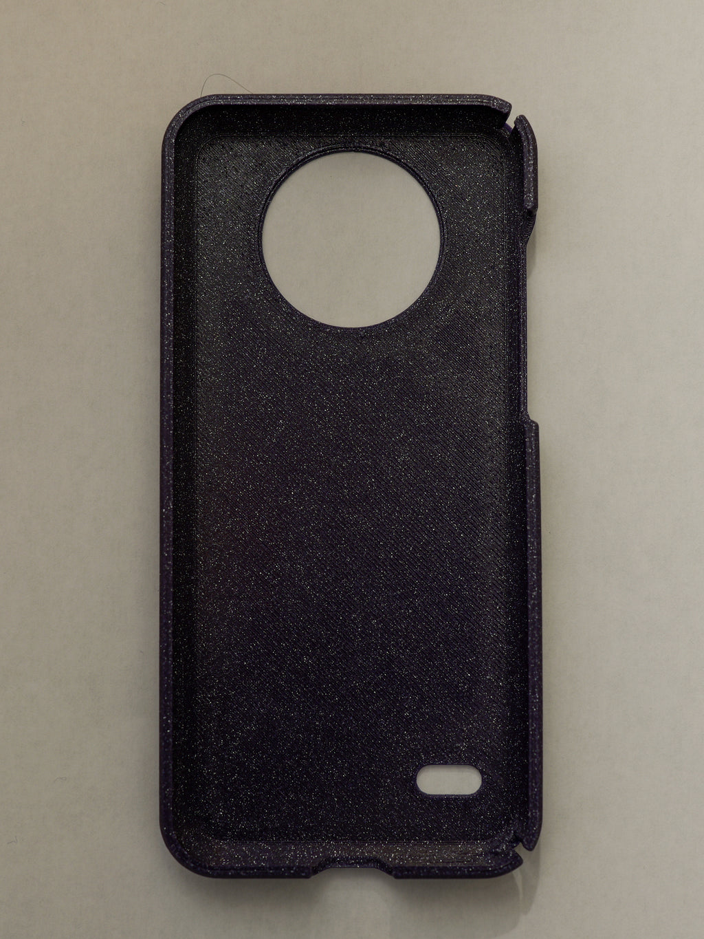purple phone case with a circular cutout on a beige background