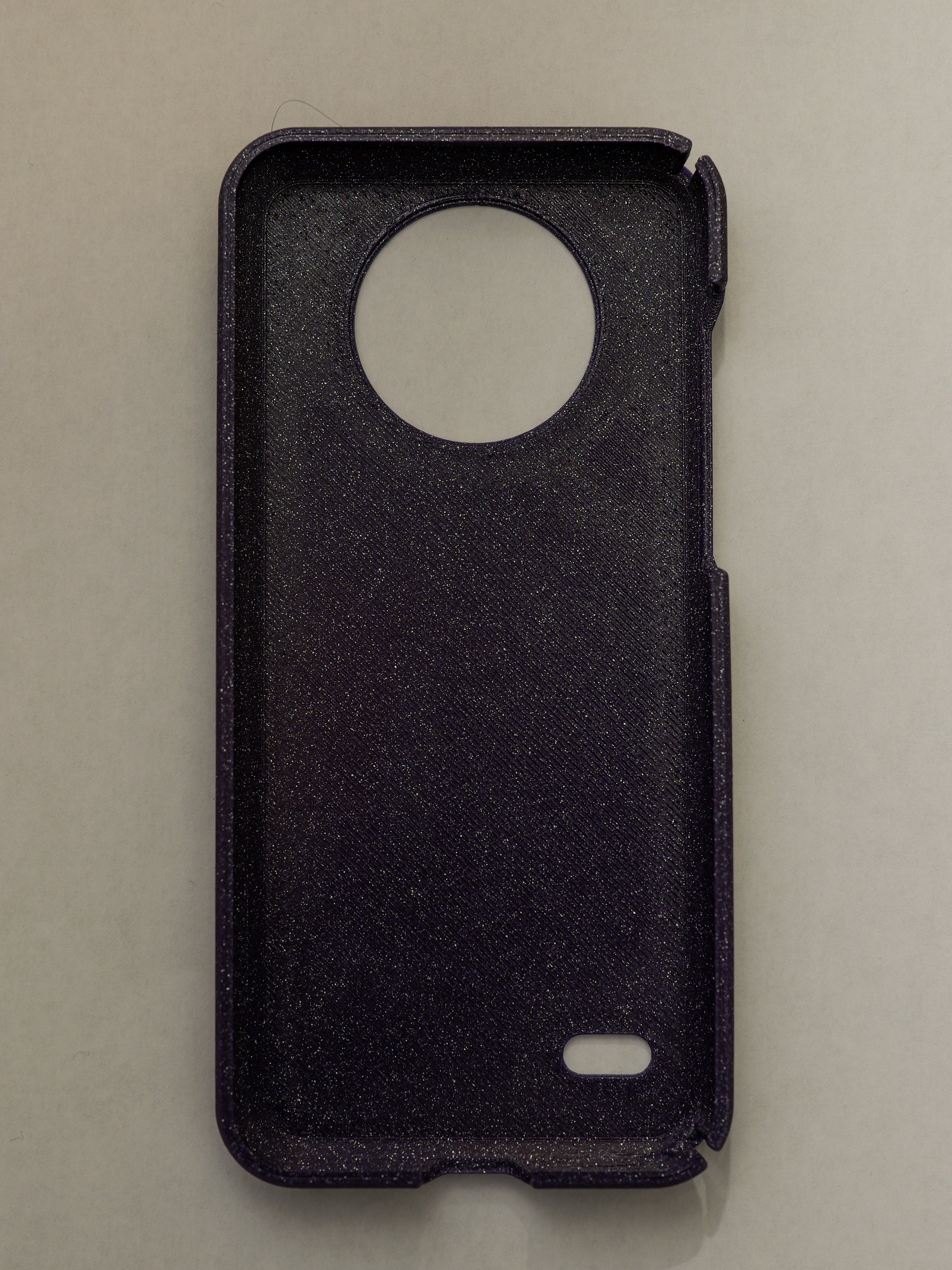 purple phone case with a circular cutout on a beige background