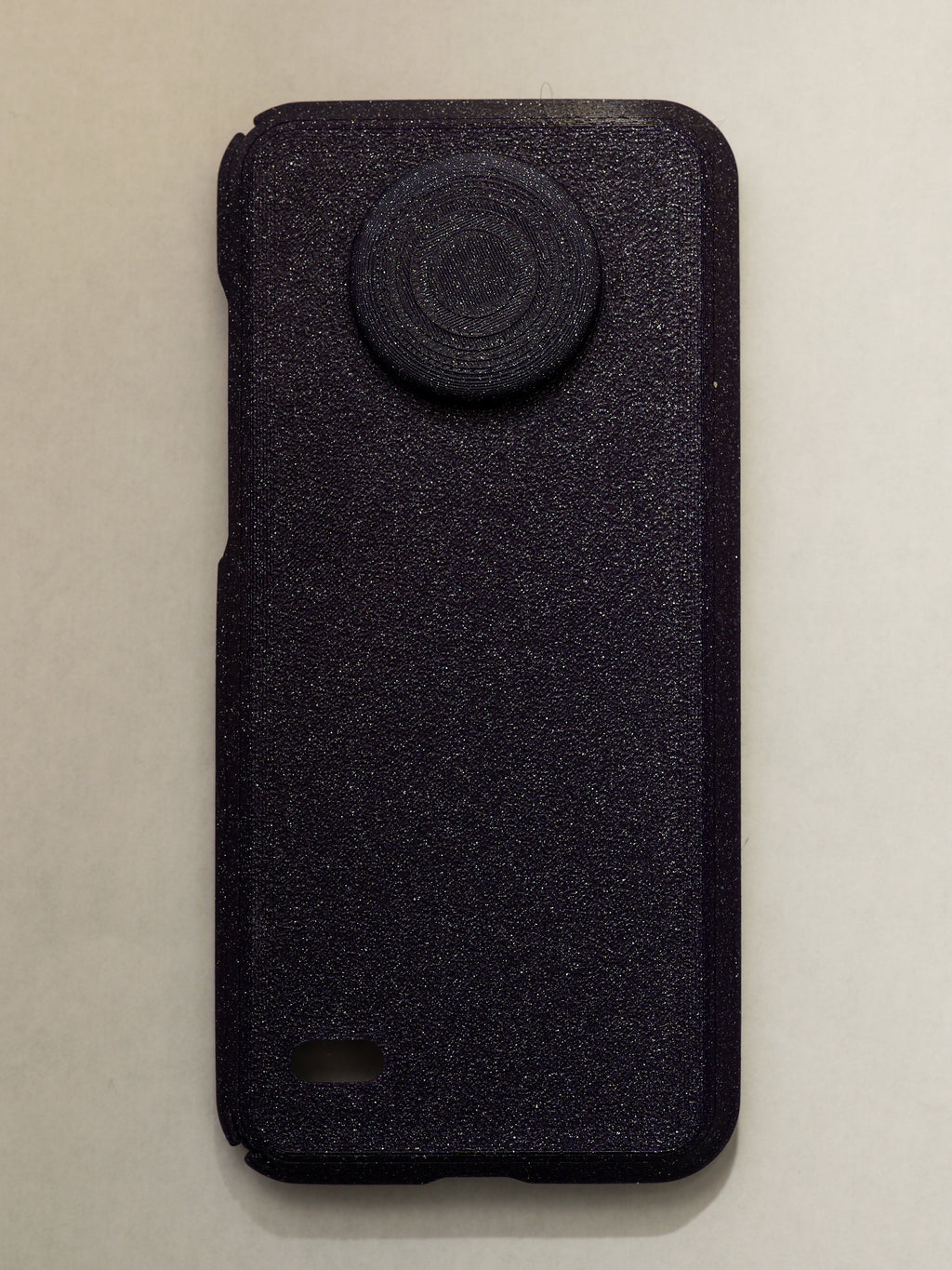 purple textured phone case with a circular design on a beige background