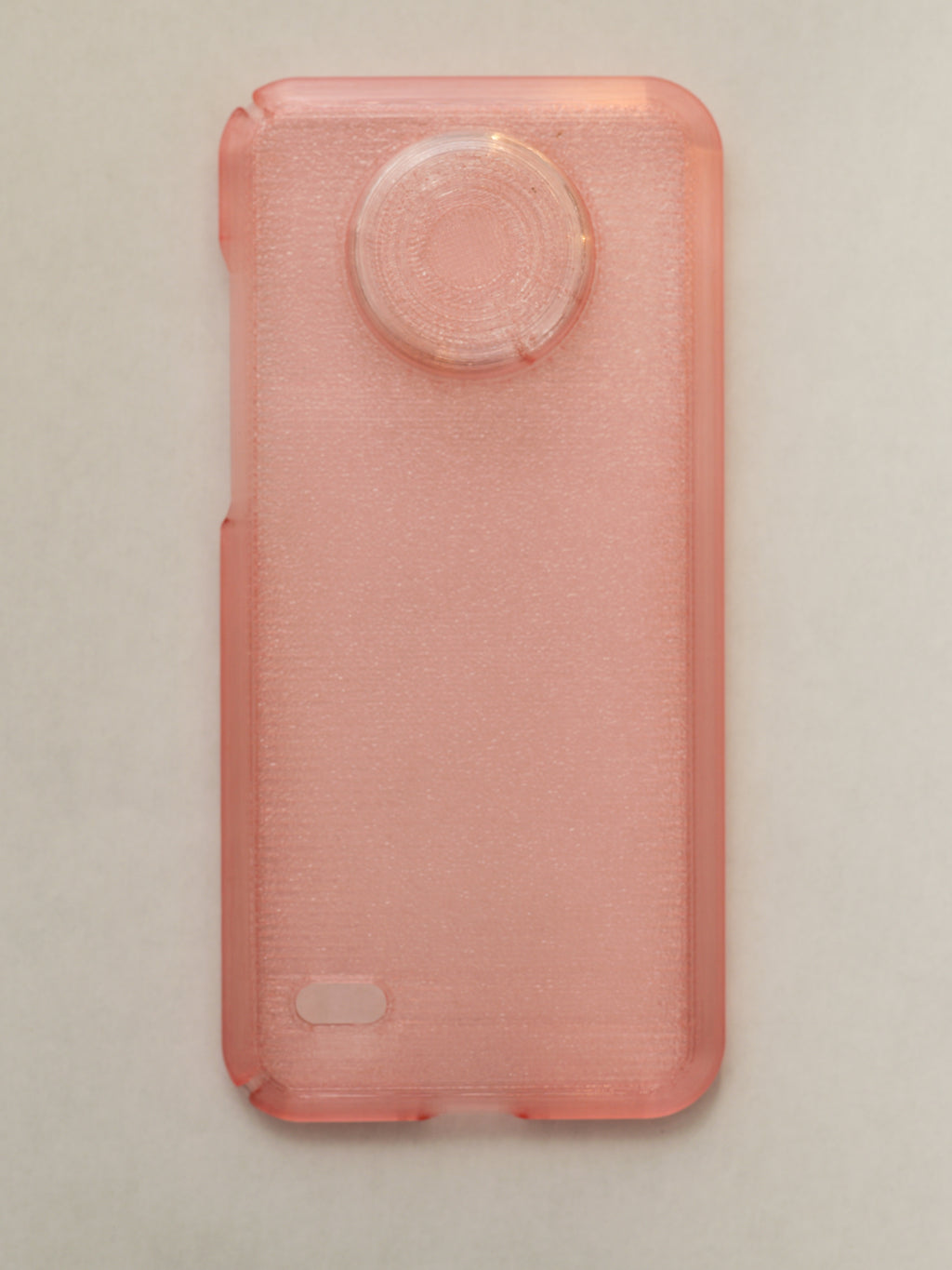 Pink phone case with textured surface on a beige background
