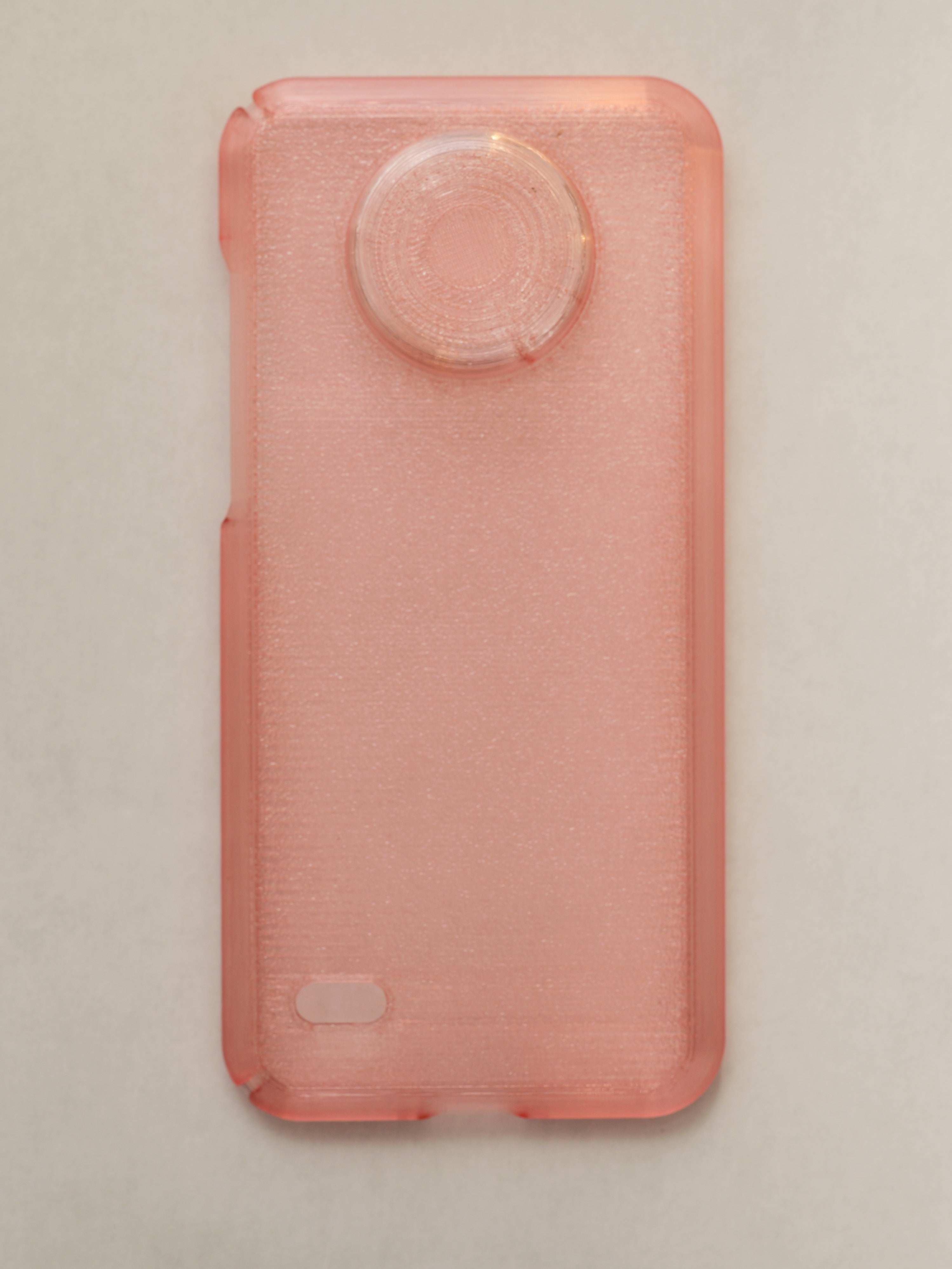 Pink phone case with textured surface on a beige background