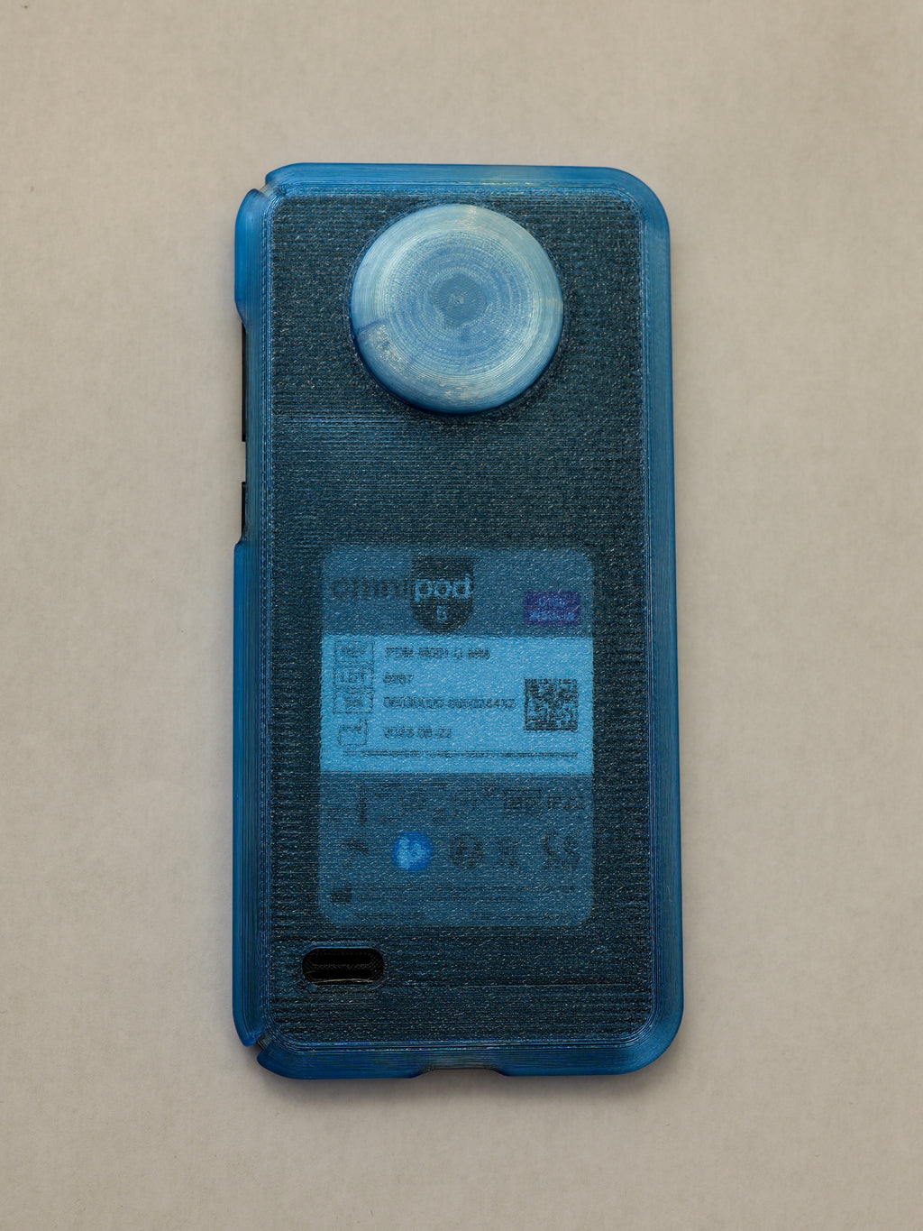 Blue electronic device with 'Omnipod' branding on a beige background